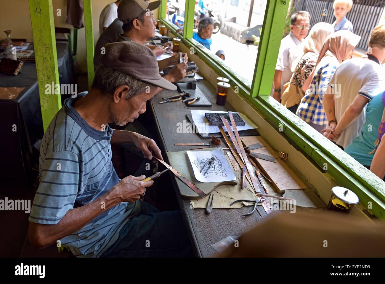 Officina di stampini su lastre di rame (tappo) utilizzati per applicare la resistenza alla cera per creare il motivo prima della tintura nel processo batik, distretto di Sondakan, solo (Surakarta) Foto Stock