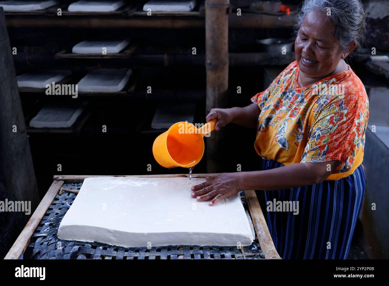Lavoratore che produce tofu, un alimento preparato con latte di soia coagulante, in una fabbrica tradizionale a conduzione familiare, Yogyakarta, Giava, Indonesia, Sud-est asiatico, Asia, Asia Foto Stock