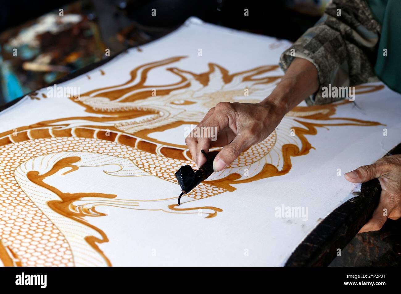Donna che usa cera calda per delineare il disegno di un drago, Batik Production, Yogyakarta, Java, Indonesia, sud-est asiatico, Asia, Asia Foto Stock