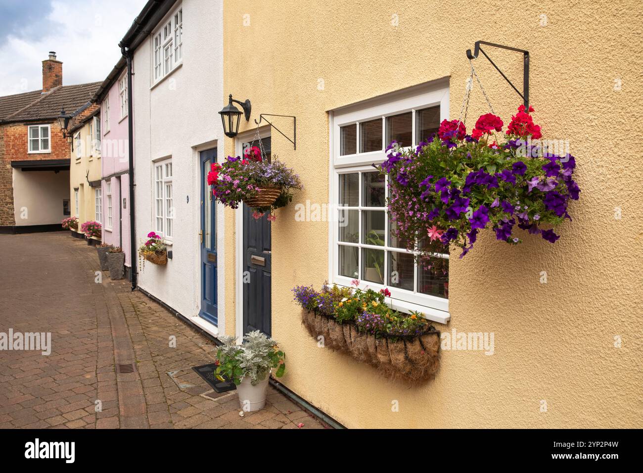 Regno Unito, Inghilterra, Rutland, Oakham, Dean’s Street, cestini appesi «Dead Man’s Lane» fuori dai cottage Foto Stock