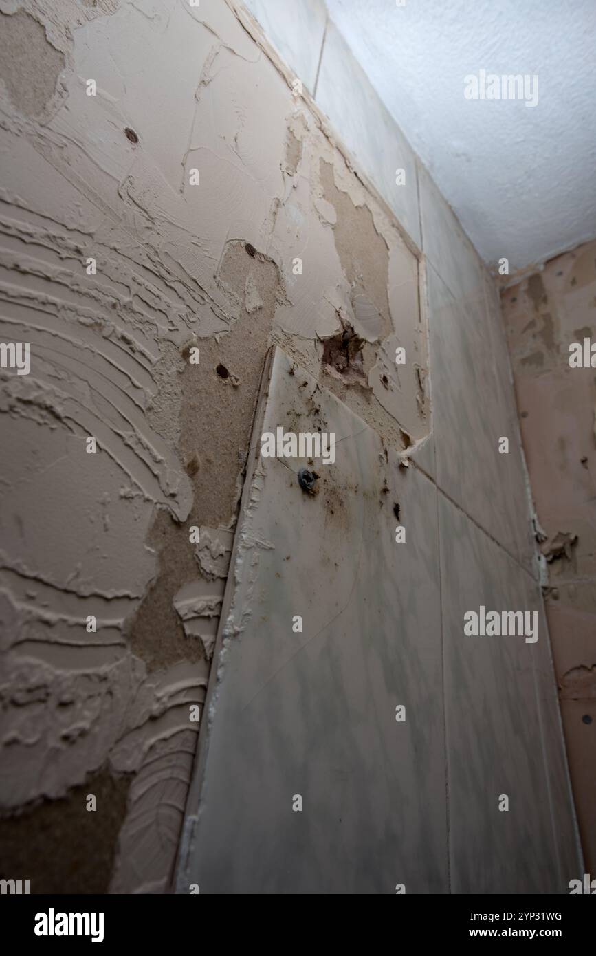 Piastrelle di pareti rotte Rimozione del miglioramento della posizione iniziale delle vecchie piastrelle Foto Stock