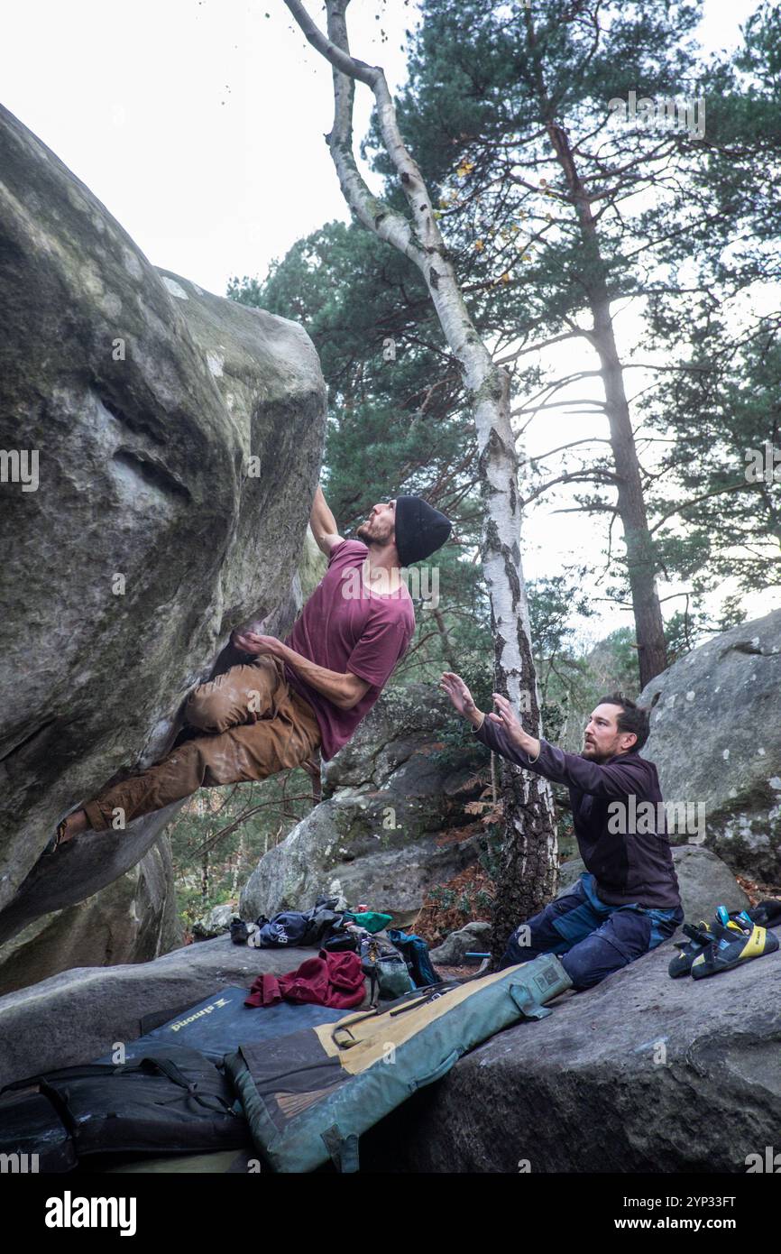 Michael Bunel/le Pictorium - ARRAMPICATA SU BLOCCHI NELLA FORESTA DI FONTAINEBLEAU - 05/01/2016 - Francia/Fontainebleau - due fratelli praticano il bouldering nella foresta di Fontainebleau. Il bouldering comporta l'arrampicata di rocce di altezza inferiore a 8 metri senza l'aiuto di una corda. I materassi, chiamati collisioni, posizionati a terra proteggono dalle cadute. Una persona può essere aggiunta al dispositivo per evitare cadute cattive; lo chiamiamo lo spotter nel gergo dell'arrampicata. Fontainebleau è conosciuta in tutto il mondo per essere la culla del bouldering. Il massiccio forestale di Fontainebleau accoglie 4 milioni di visitatori arrampicati ogni anno Foto Stock