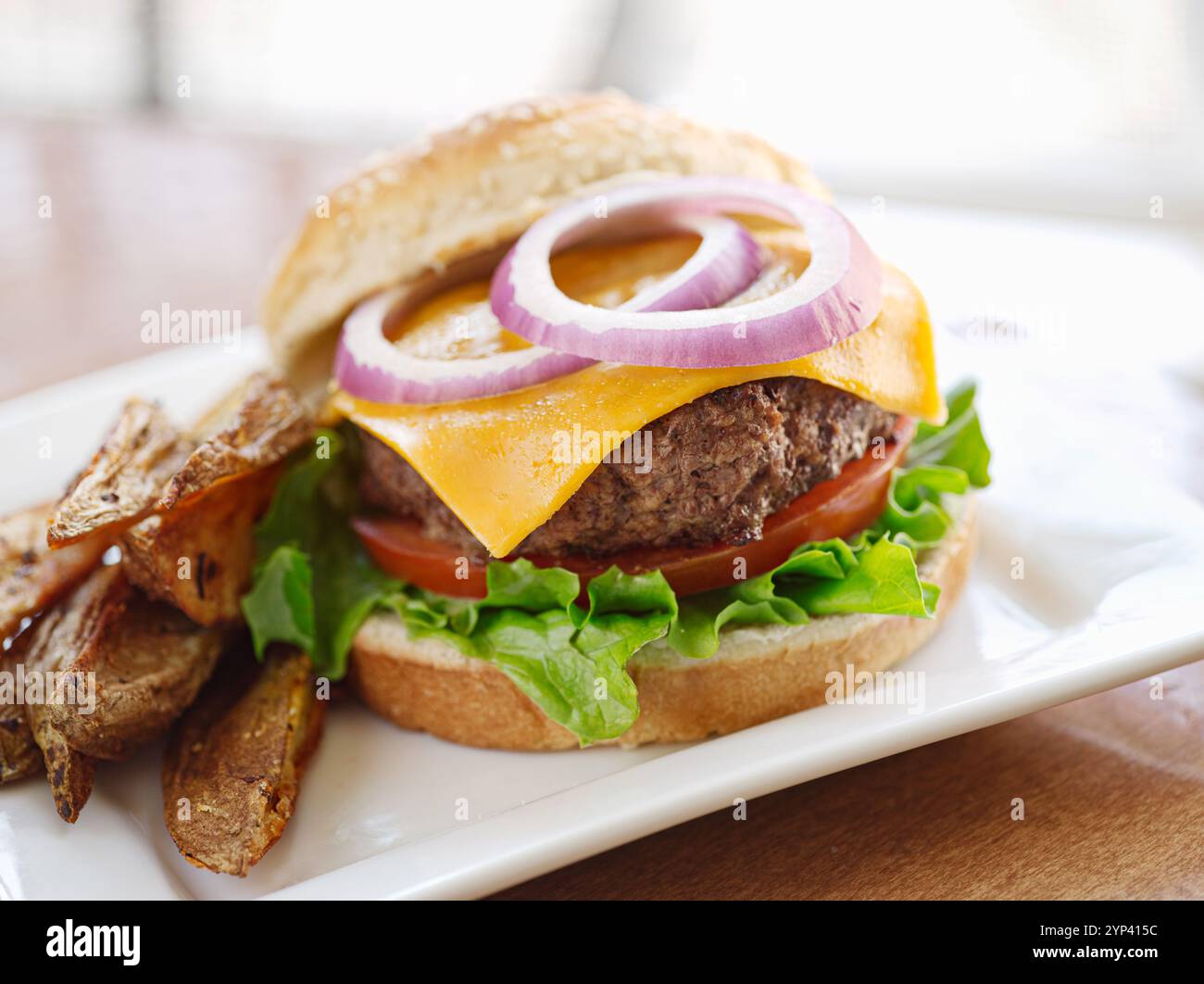 cheeseburger con patatine fritte e ketchup sul tavolo rustico Foto Stock