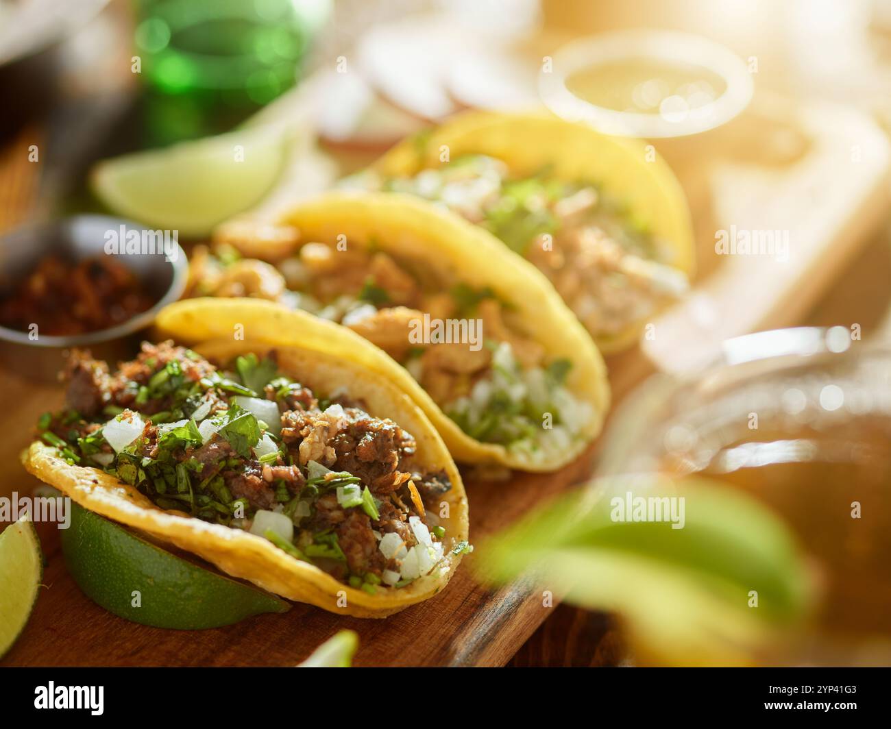 tre tipi di tacos messicani da strada con carnitas barbacoa e chicharrón con riflesso dell'obiettivo Foto Stock