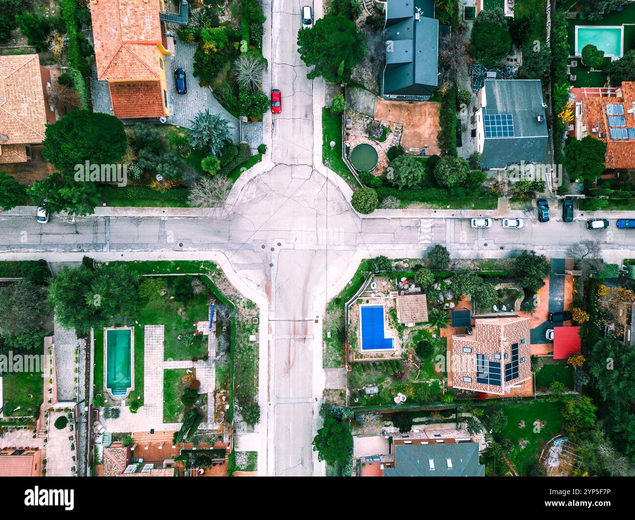 Scatta foto aeree dall'alto su un quartiere residenziale di periferia con pannelli solari, strade e parchi Foto Stock