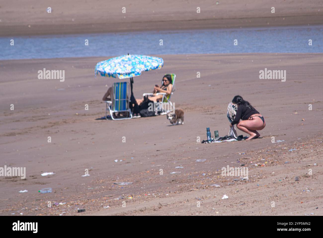 Persone sulla spiaggia con un ombrellone Foto Stock