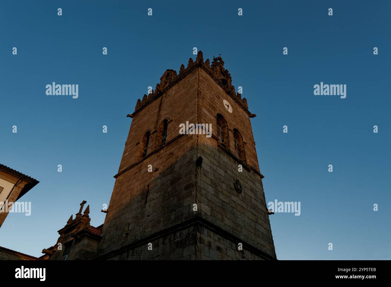 Torre dell'orologio Igreja de Nossa Senhora da Oliveira illuminata all'ora d'oro a Guimarães Foto Stock