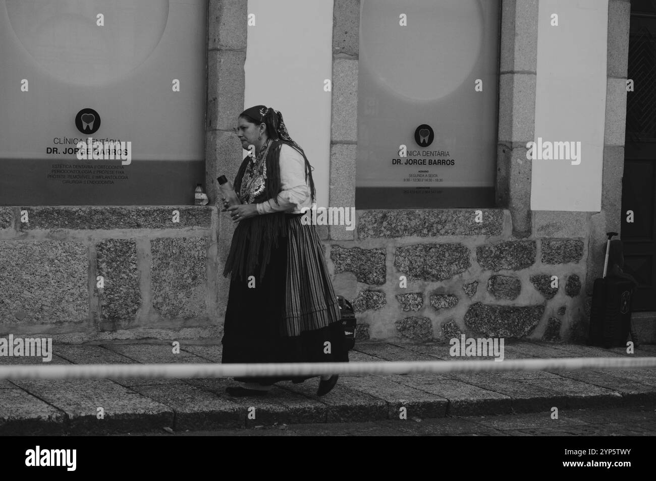 Donna in un tradizionale abbigliamento portoghese che cammina durante le Festas Gualterianas in b&W Foto Stock