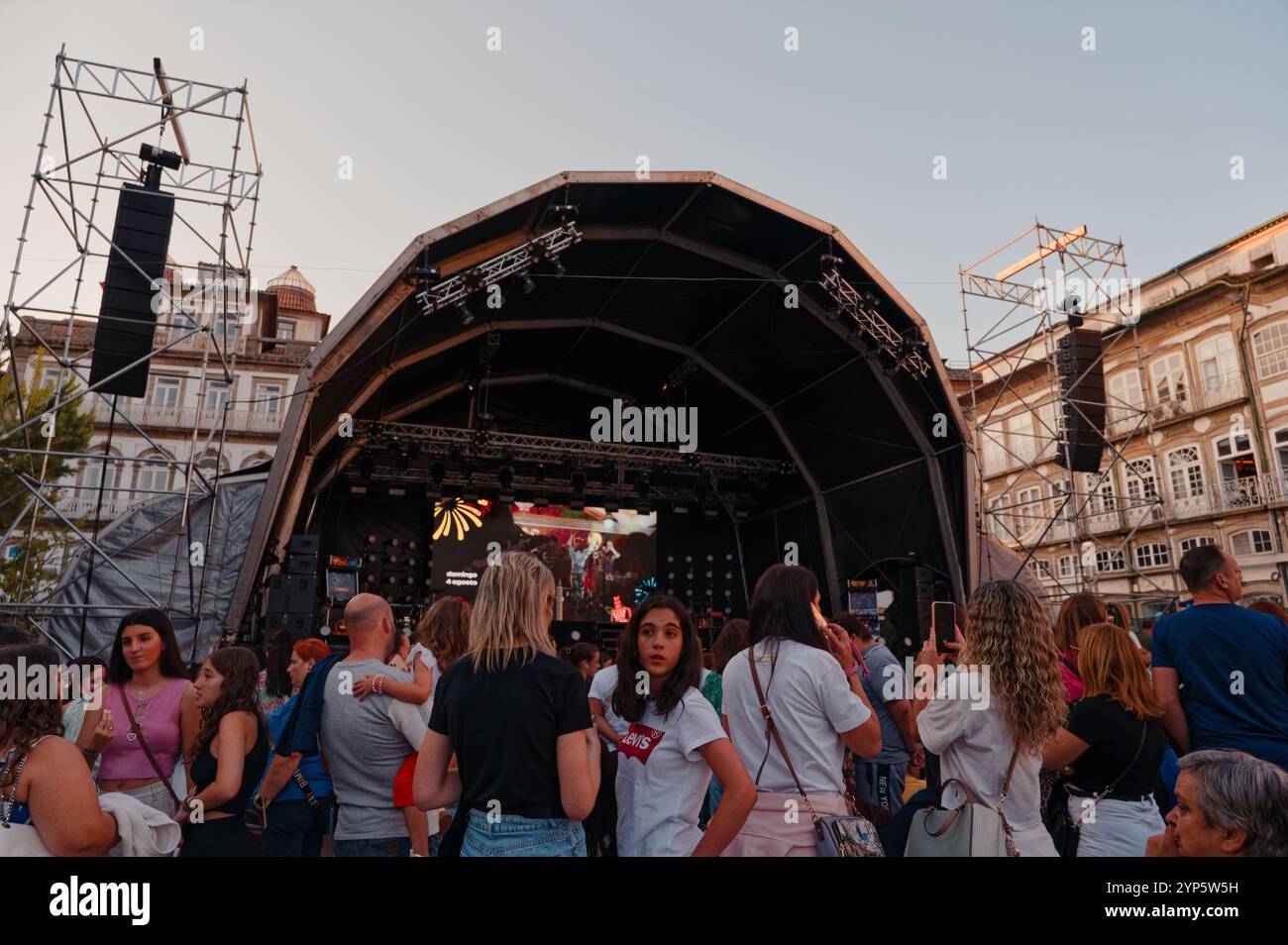 Folle eccitate si riuniscono in un palco di concerti all'aperto durante i festival della città di Guimarães Foto Stock