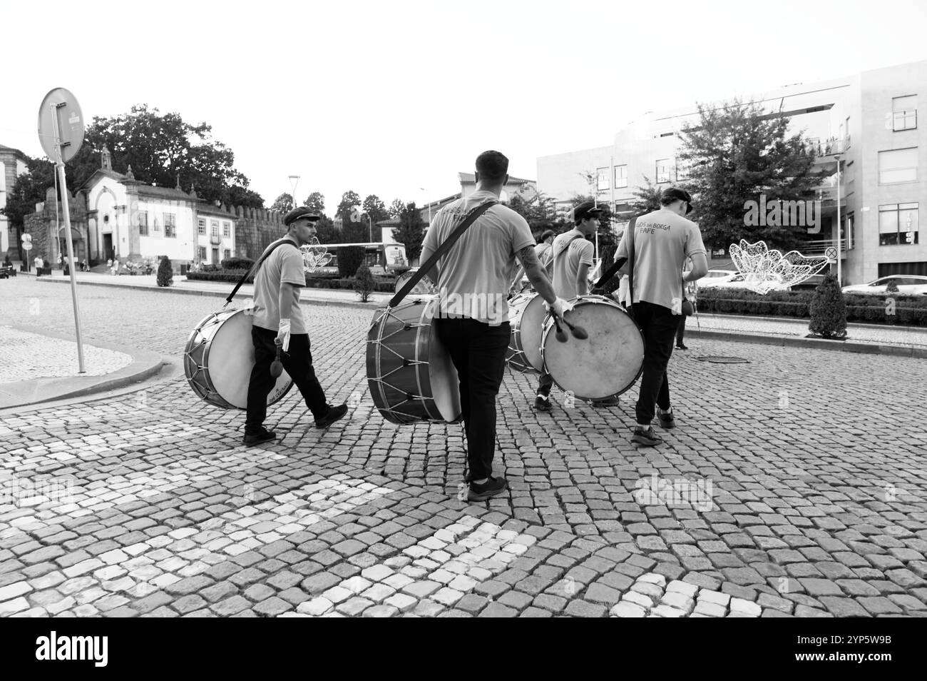 Batteristi che marciano per le strade acciottolate di Guimarães in monocromia Foto Stock