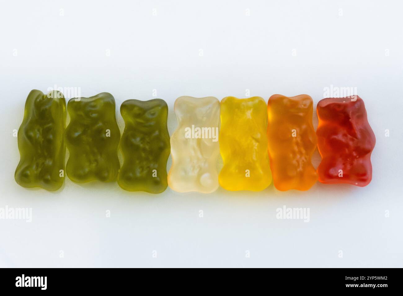 foto in studio da una fila di coloratissimi orsetti di gelatina. Si trova su uno sfondo bianco pulito. Concetto di mangiare dolce, cose dolci e carine e sugo in eccesso Foto Stock