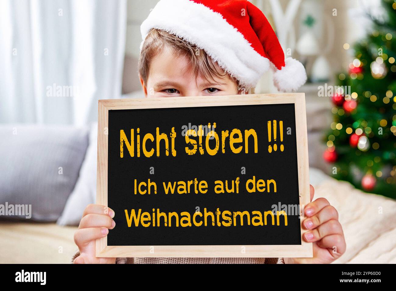 26 novembre 2024: Un bambino in attesa di Natale tiene un cartello con il messaggio: Non disturbarmi sto aspettando Babbo Natale. FOTOMONTAGGIO *** Ein Kind in weihnachtlicher Vorfreude hält ein liebevoll gestaltetes Schild mit der Botschaft: Nicht stören Ich warte auf den Weihnachtsmann. FOTOMONTAGE Foto Stock