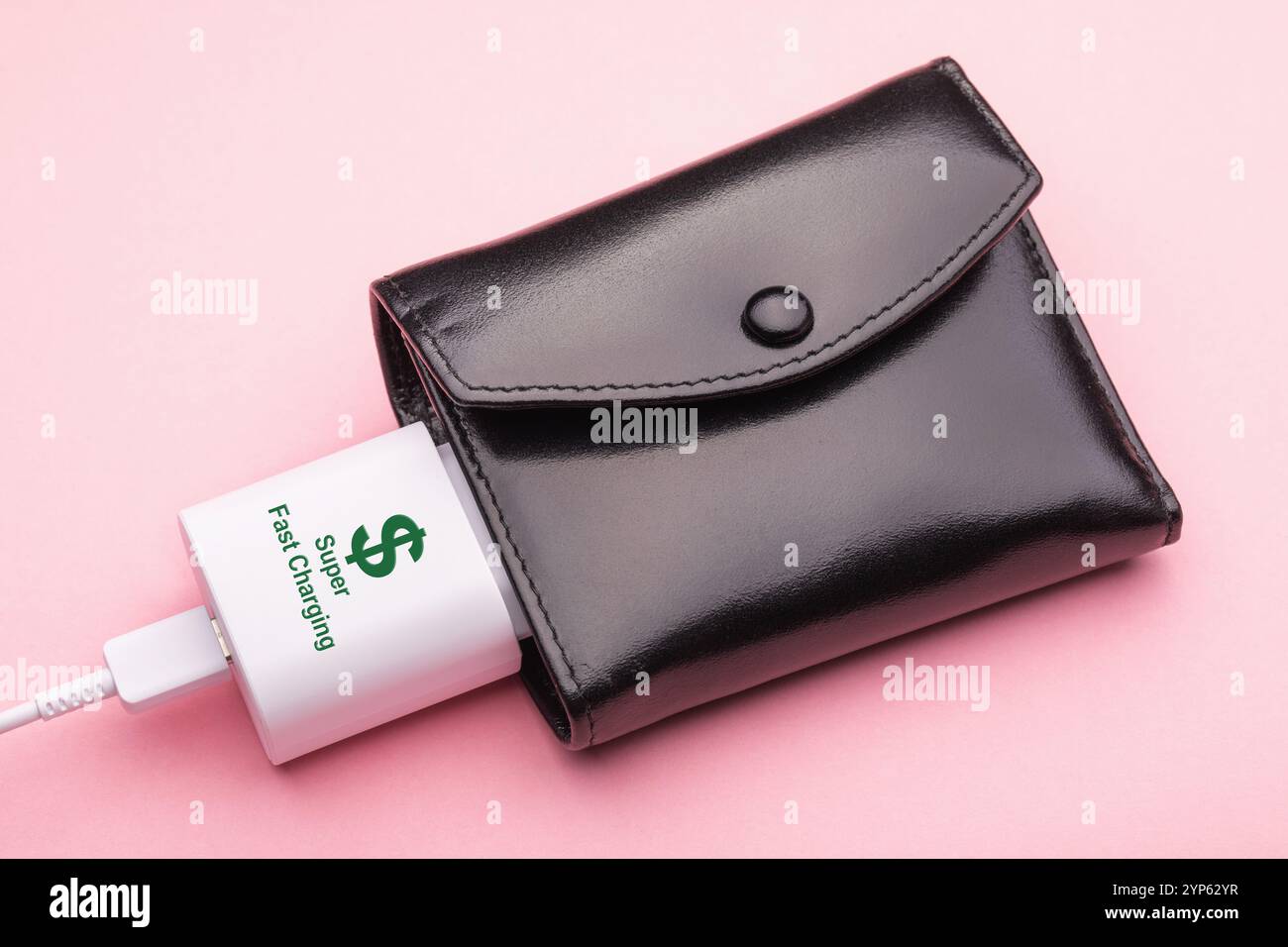 Un caricabatterie inserito in un portafoglio, un concetto sul tema del guadagnare rapidamente Foto Stock