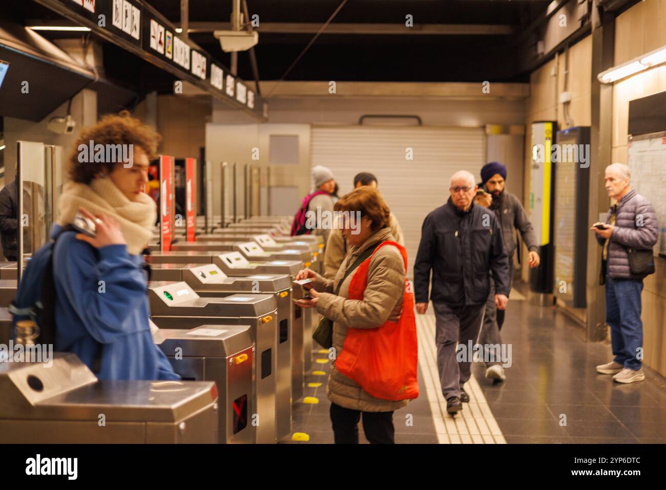 Barcellona-Spagna, 28 novembre 2024. L'affollato ingresso della stazione della metropolitana di Barcellona mette in mostra l'atmosfera vibrante e l'architettura moderna della città Foto Stock