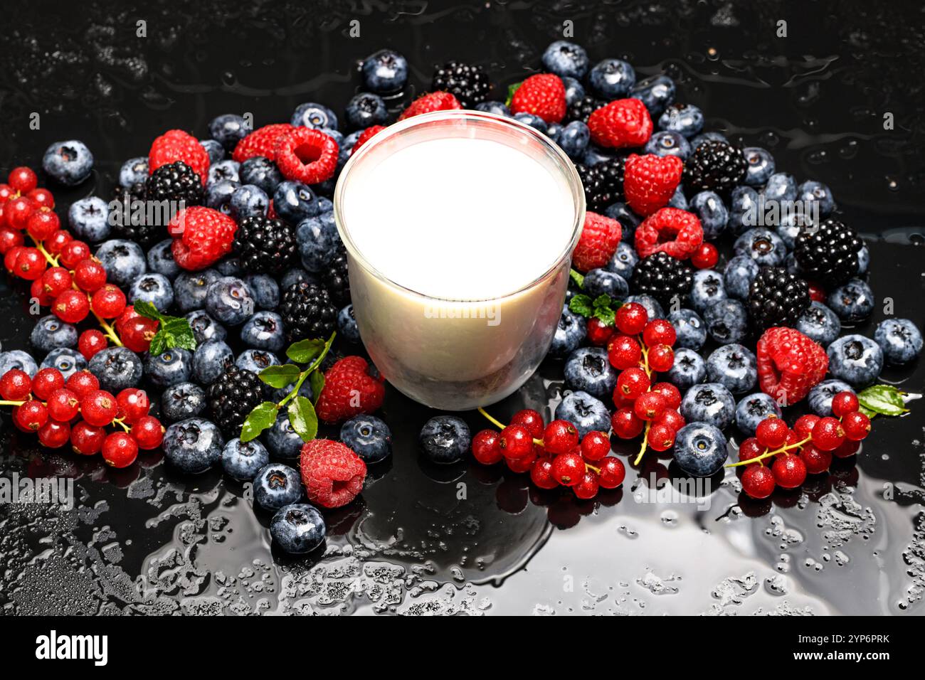 Sfondo frutti di bosco. Prima colazione salutare. Frutti di bosco con un bicchiere di latte. Sfondo di bacche fresche. Mirtilli, more e raspberri Foto Stock