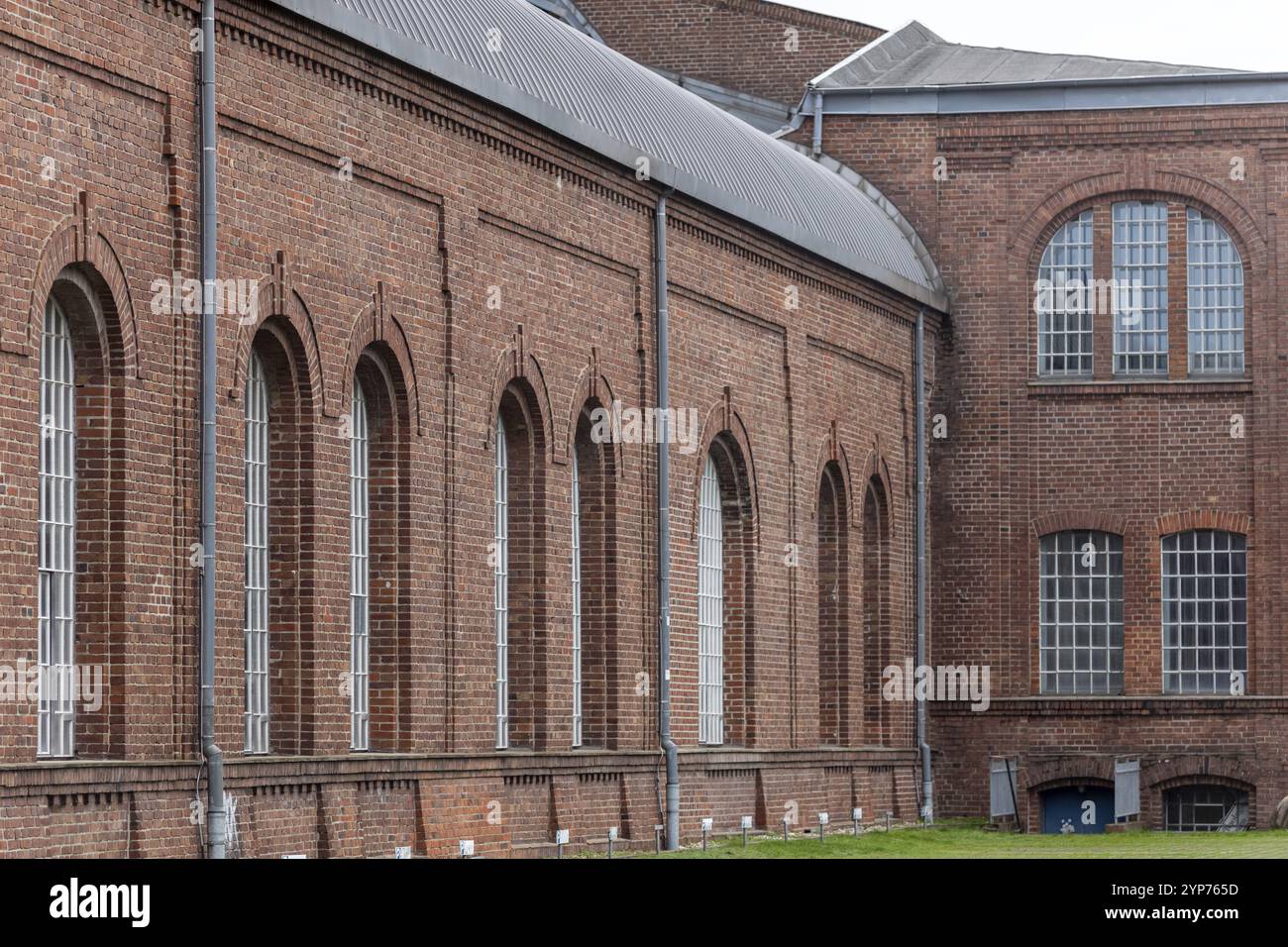 Edificio storico con finestre ad arco multiple su una facciata in mattoni, in stile industriale Foto Stock