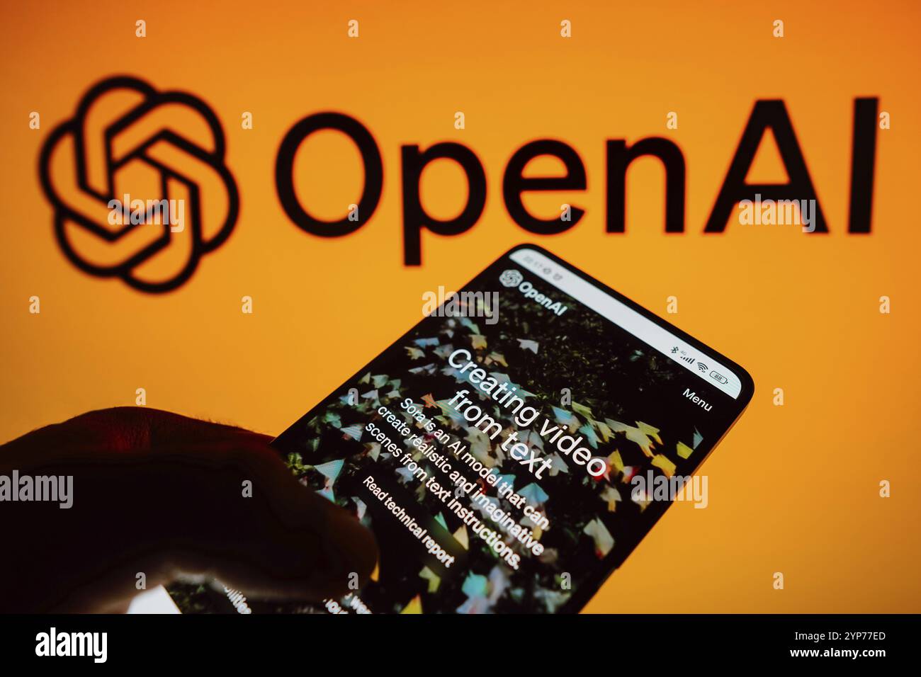 In questa immagine, la home page di Sora, OpenAI video intelligenza artificiale viene visualizzata sullo schermo di uno smartphone e sullo sfondo del logo OpenAI Foto Stock
