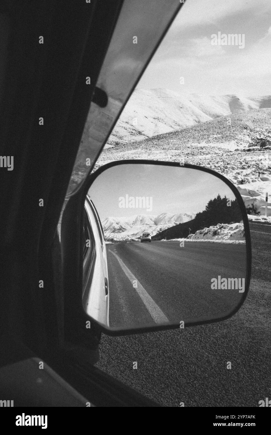 Vista di un paesaggio innevato di montagna attraverso lo specchio laterale di un'auto, lago Tekapo, nuova Zelanda, Oceania Foto Stock