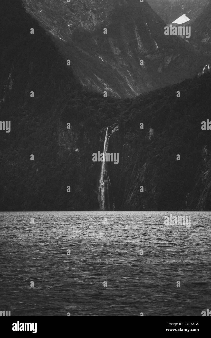 Montagne torreggianti e una cascata in un impressionante design bianco e nero, Milford Sound, nuova Zelanda, Oceania Foto Stock