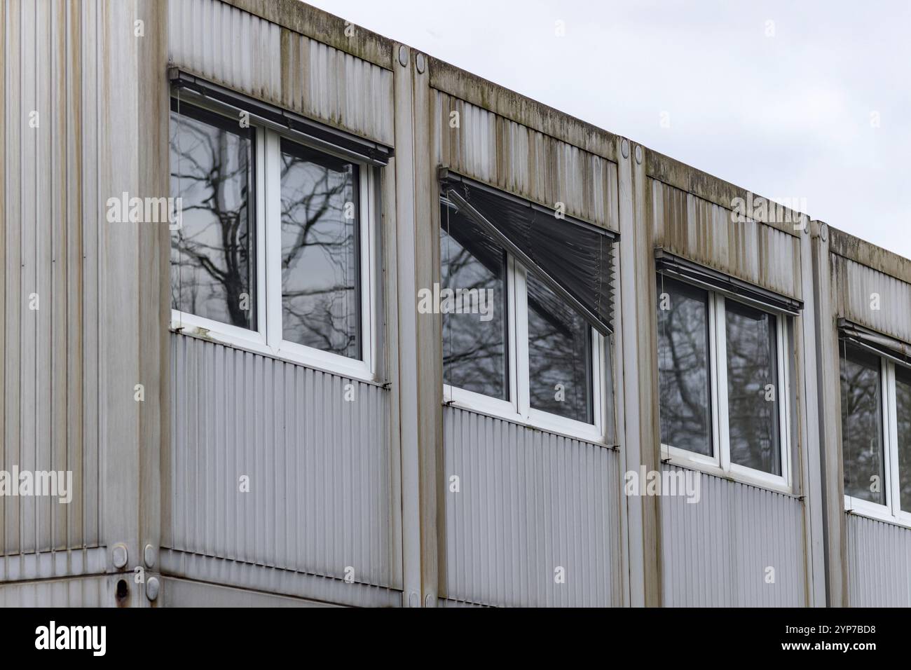 Edificio industriale con una facciata e finestre in metallo che riflettono un ambiente coperto Foto Stock