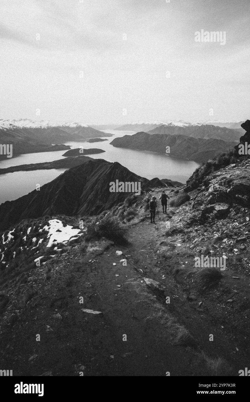 Escursione in montagna su un sentiero innevato con un'ampia vista di un lago bianco e nero, Roys Peak, Wanaka, nuova Zelanda, Oceania Foto Stock