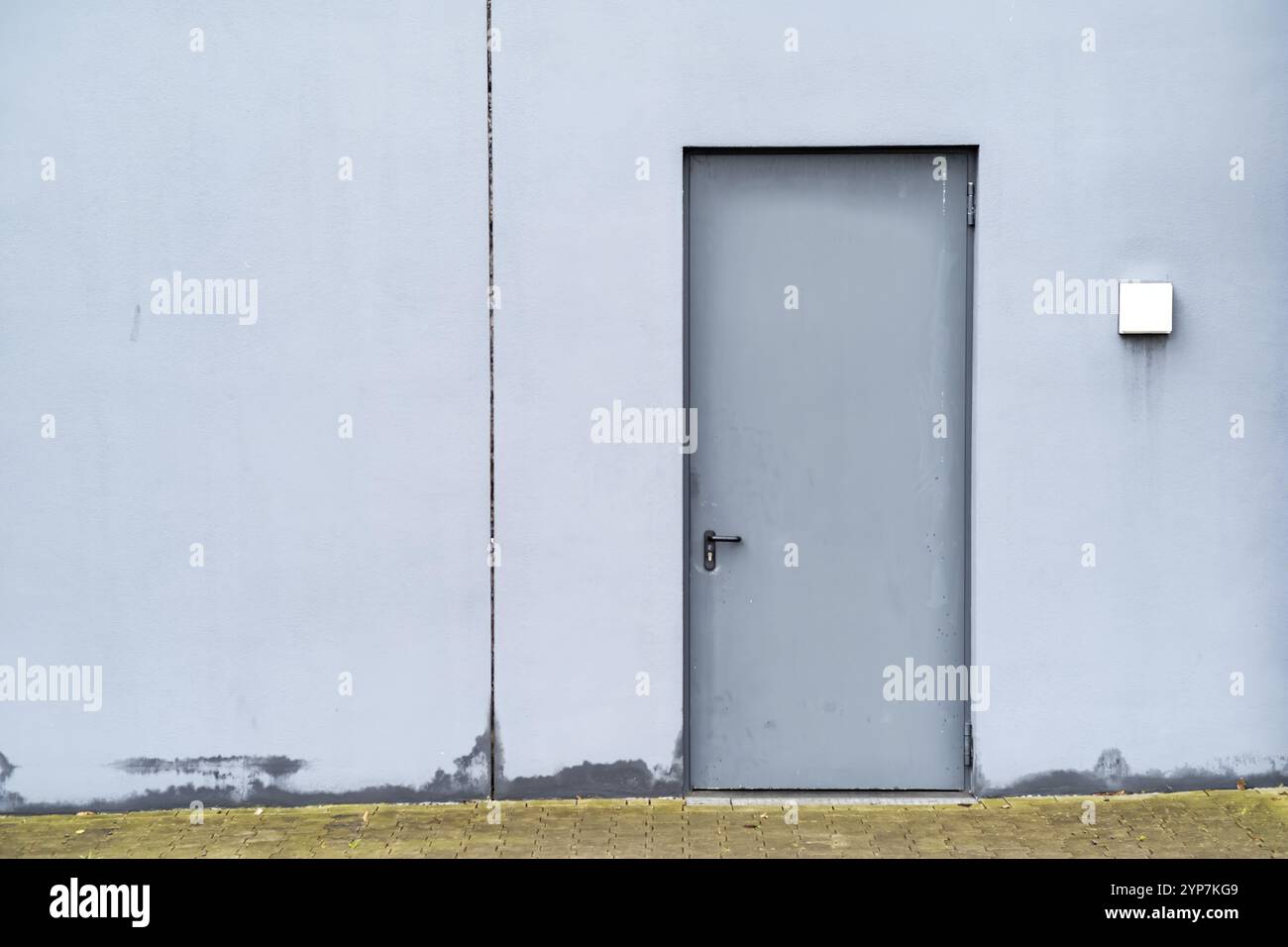 Porta in metallo grigio nel muro bianco Foto Stock