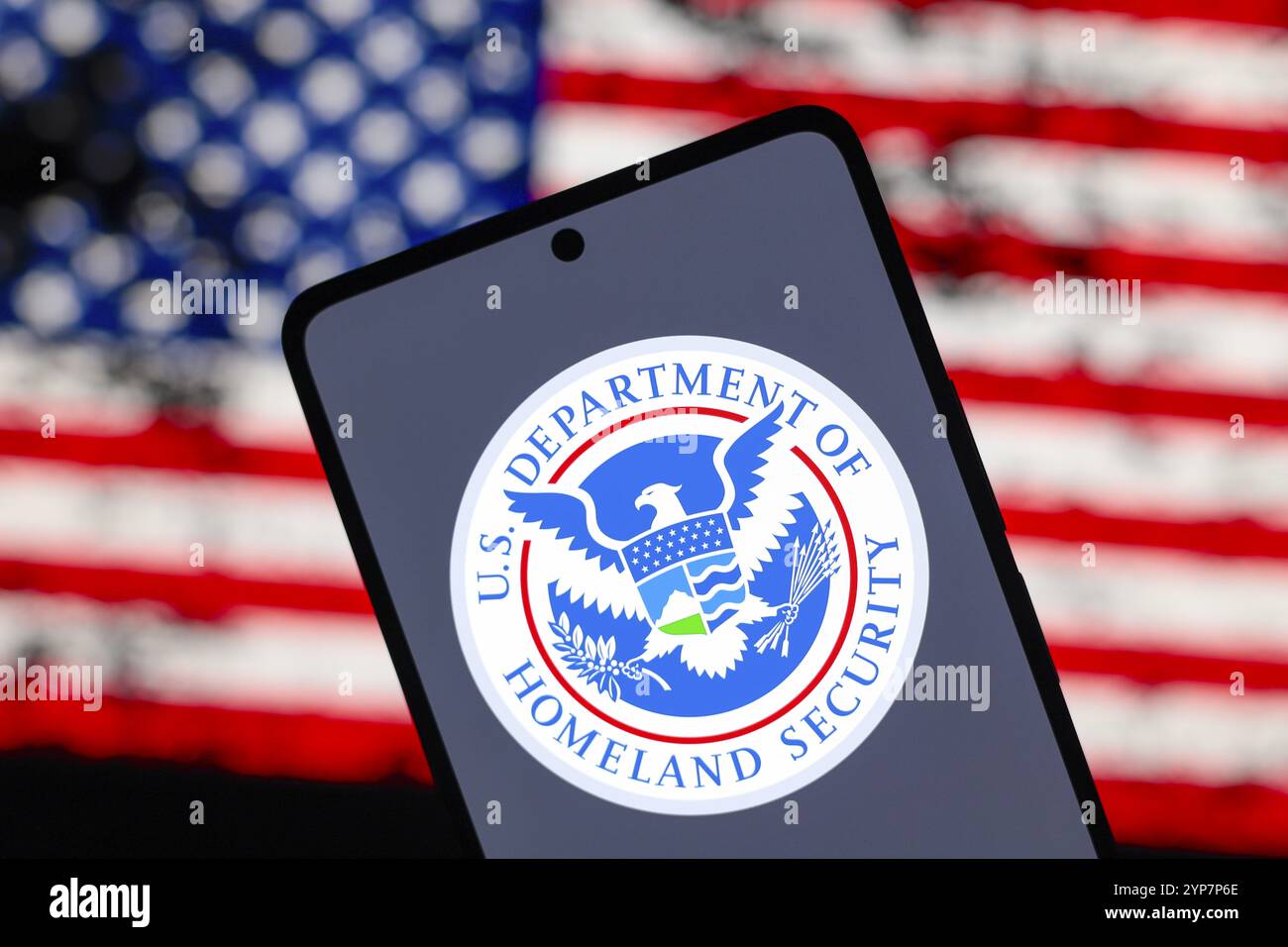 In questa immagine, il logo del Dipartimento della sicurezza interna degli Stati Uniti (DHS) viene visualizzato sullo schermo di uno smartphone e sullo sfondo Foto Stock