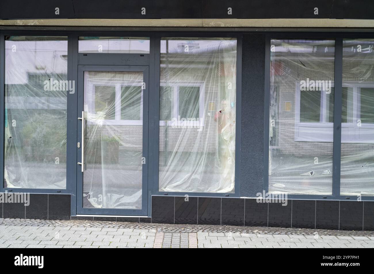 Finestre vetrate e porte rivestite con fogli di plastica protettivi durante la ristrutturazione o la costruzione di edifici Foto Stock