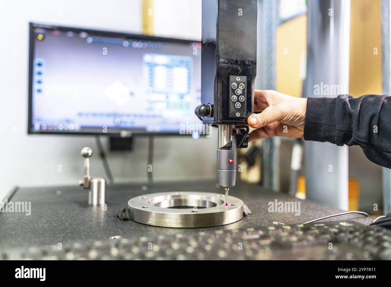 Primo piano di un tecnico che lavora con una macchina di verifica e misurazione tridimensionale in un'innovativa fabbrica di metalli cnc Foto Stock