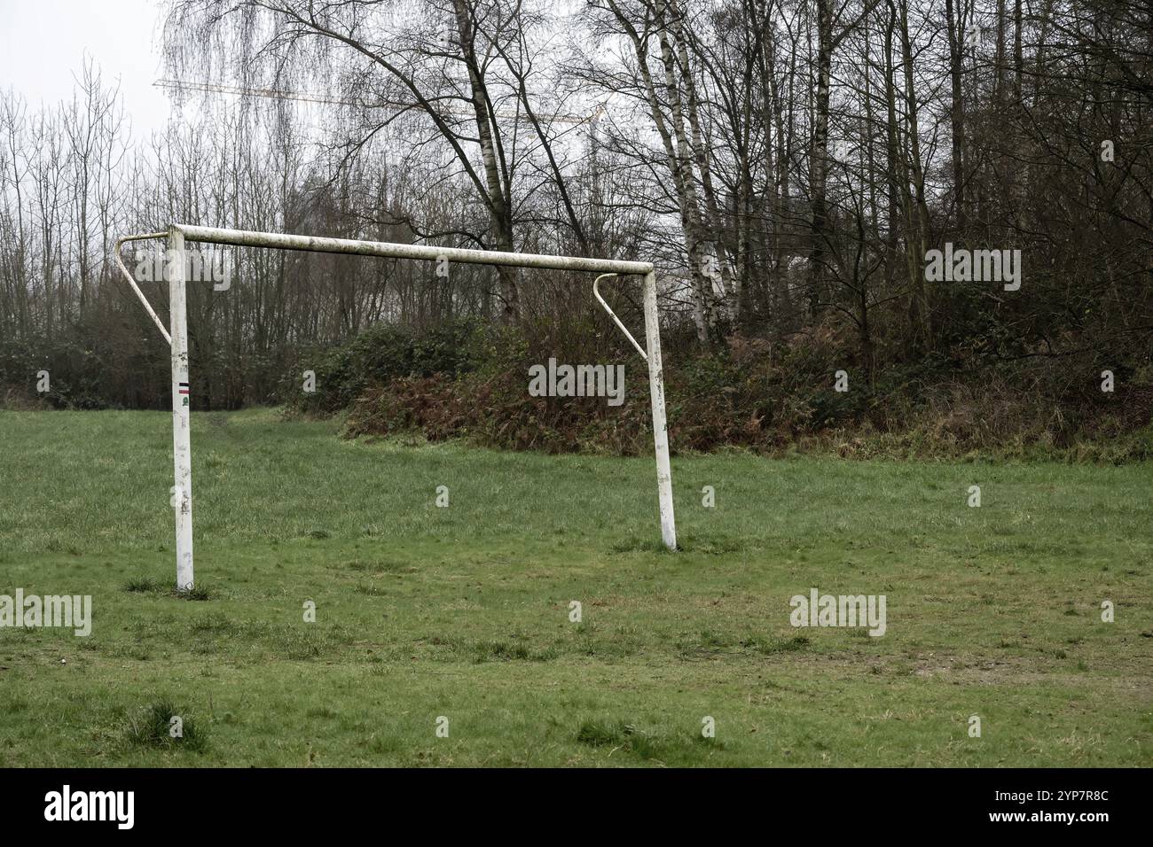 Campo da calcio mal tenuto con vecchio obiettivo di calcio sotto la pioggia Foto Stock