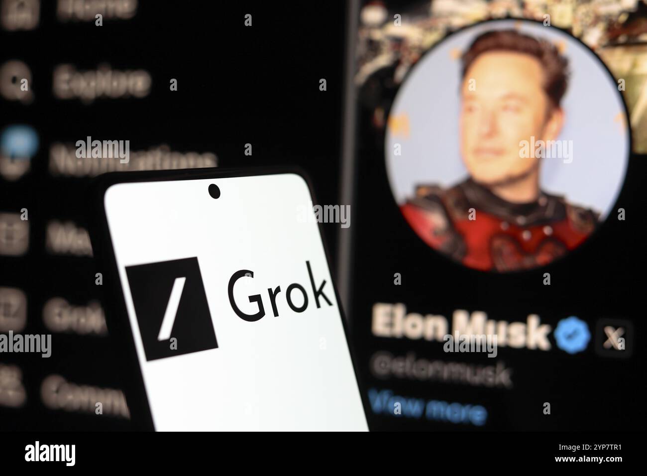 In questa immagine, il logo Grok visto visualizzato su uno smartphone con il profilo ufficiale di Elon Musk, del social network X nel retro Foto Stock