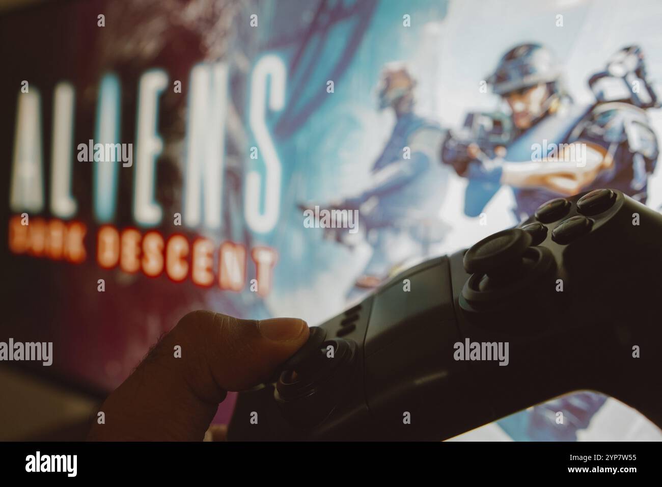 In questa immagine, il gioco con il logo Aliens: Dark Descent viene visualizzato sullo schermo di un computer, accanto a un gamepad Foto Stock