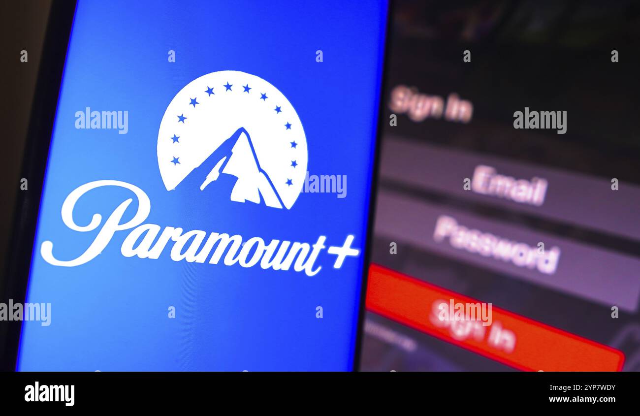 In questa immagine, il logo Paramount Plus viene visualizzato sullo schermo di uno smartphone, accanto a una schermata di accesso, con e-mail, password e accesso Foto Stock