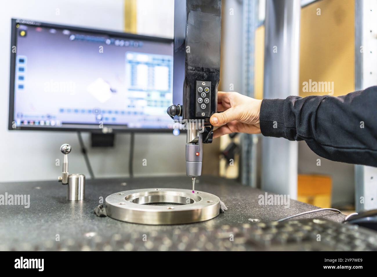 Uomo che lavora con una macchina di verifica e misurazione tridimensionale in una fabbrica innovativa cnc Foto Stock