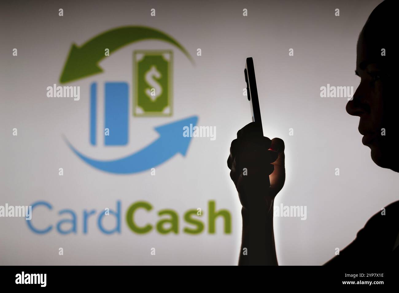 In questa illustrazione fotografica, la silhouette di una donna contiene uno smartphone con il logo CardCash sullo sfondo Foto Stock
