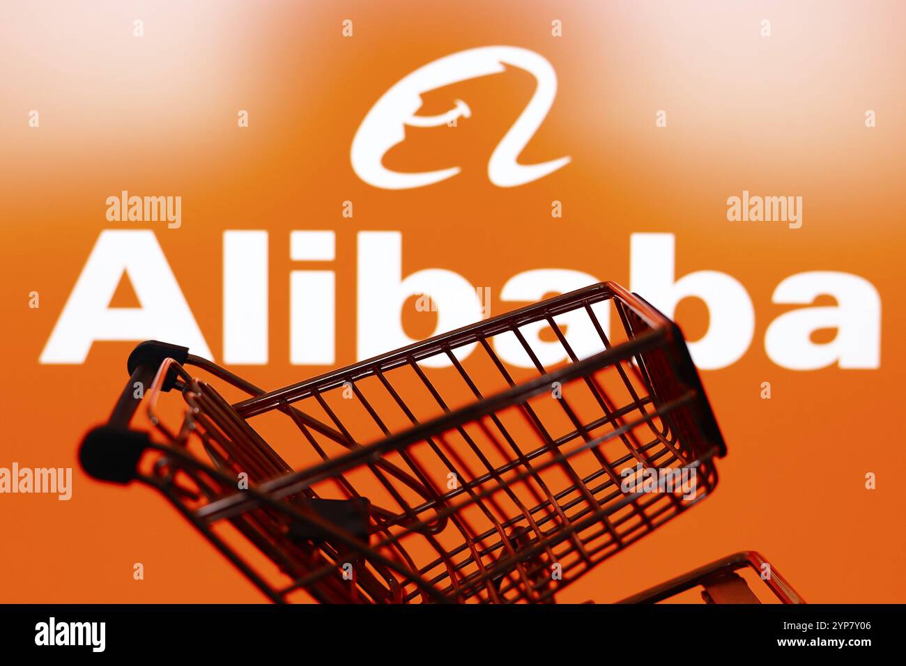 In questa immagine, un carrello della spesa è visibile di fronte al logo della società di e-commerce Alibaba Foto Stock