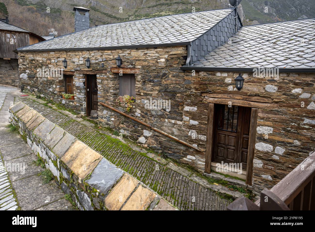 Casa in pietra con tetto in ardesia nel pittoresco villaggio di montagna che mostra architettura tradizionale Foto Stock