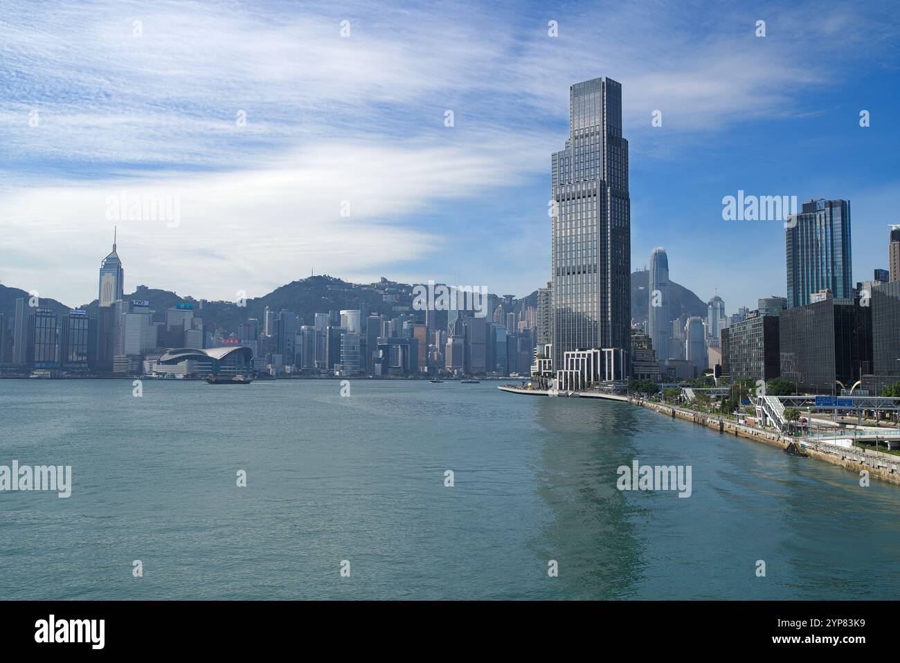 Grande grattacielo sul lungomare di Victoria Harbour che si affaccia sullo skyline in una giornata di sole. Hong Kong - 25 ottobre 2024 Foto Stock