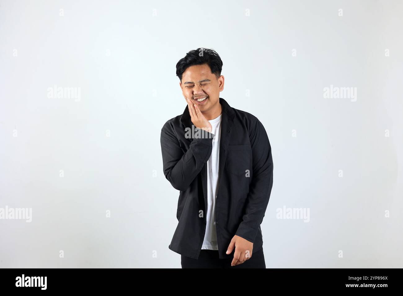 Giovane uomo asiatico in piedi su sfondo bianco toccando bocca con la mano, espressione dolorosa a causa di mal di denti o malattie dentali sui denti Foto Stock