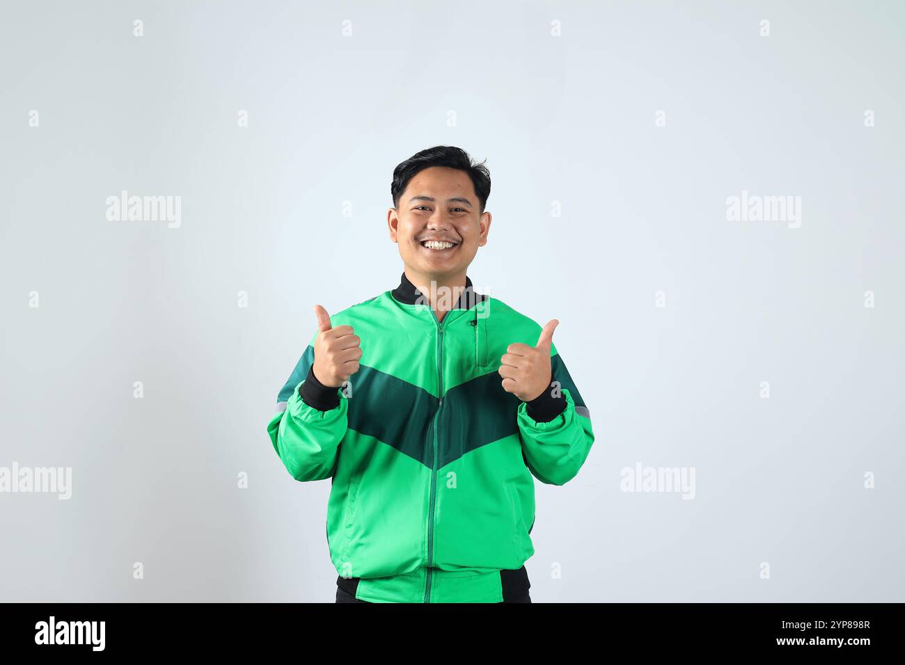 Giovane Asiatico Online driver con Happy Expression e Thumbs Up, isolato su bianco Foto Stock