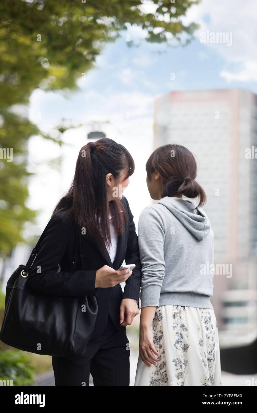 Donna che cammina su uno smartphone Foto Stock