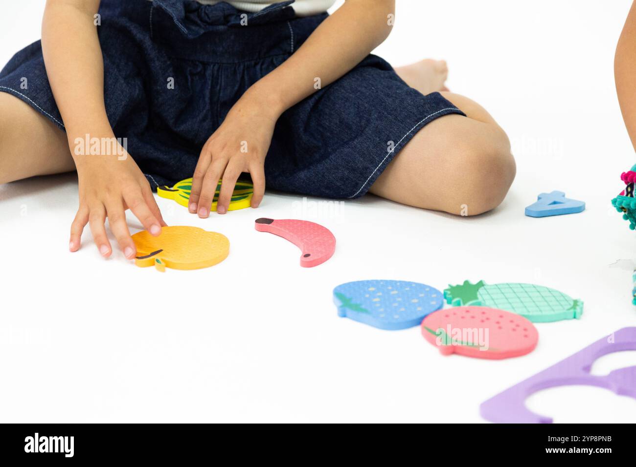 Una ragazza che gioca con un puzzle Foto Stock
