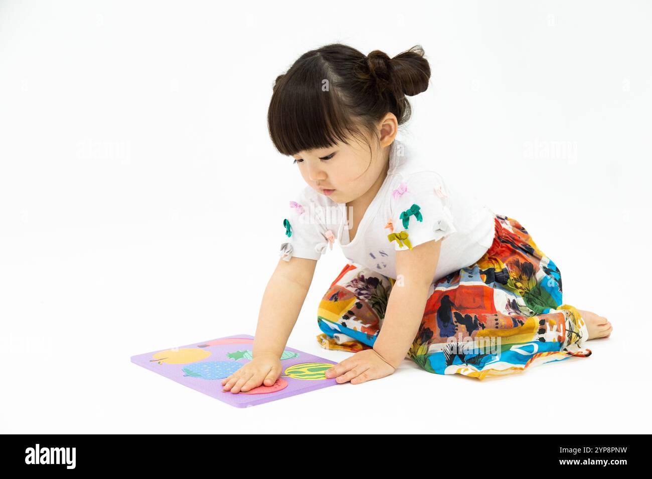 Una ragazza che gioca con un puzzle Foto Stock