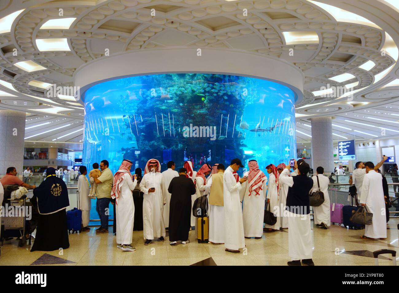 Gli arabi sauditi indossano abiti tradizionali presso l'acquario più grande del mondo, l'aeroporto internazionale King Abdulaziz, Jeddah, Arabia Saudita. No MR o PR Foto Stock