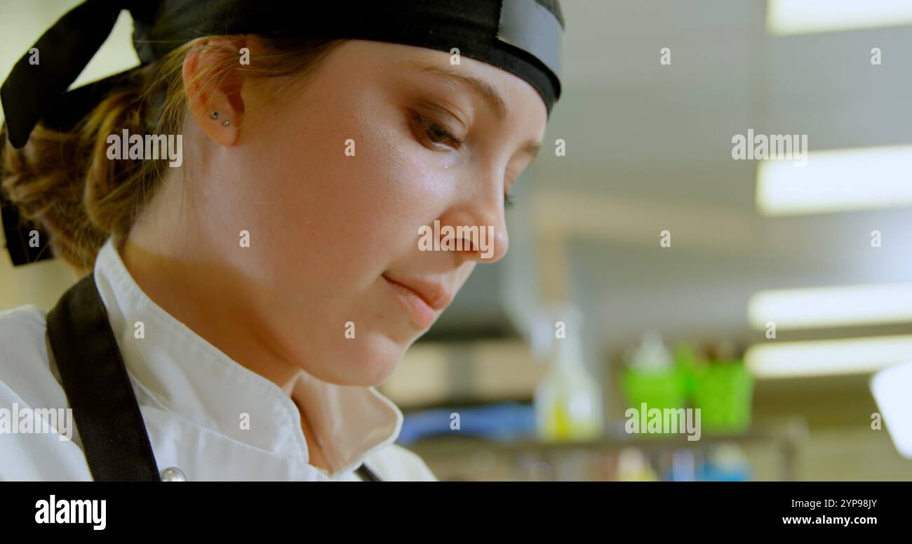 Primo piano di una chef donna che lavora in cucina al ristorante 4K Foto Stock