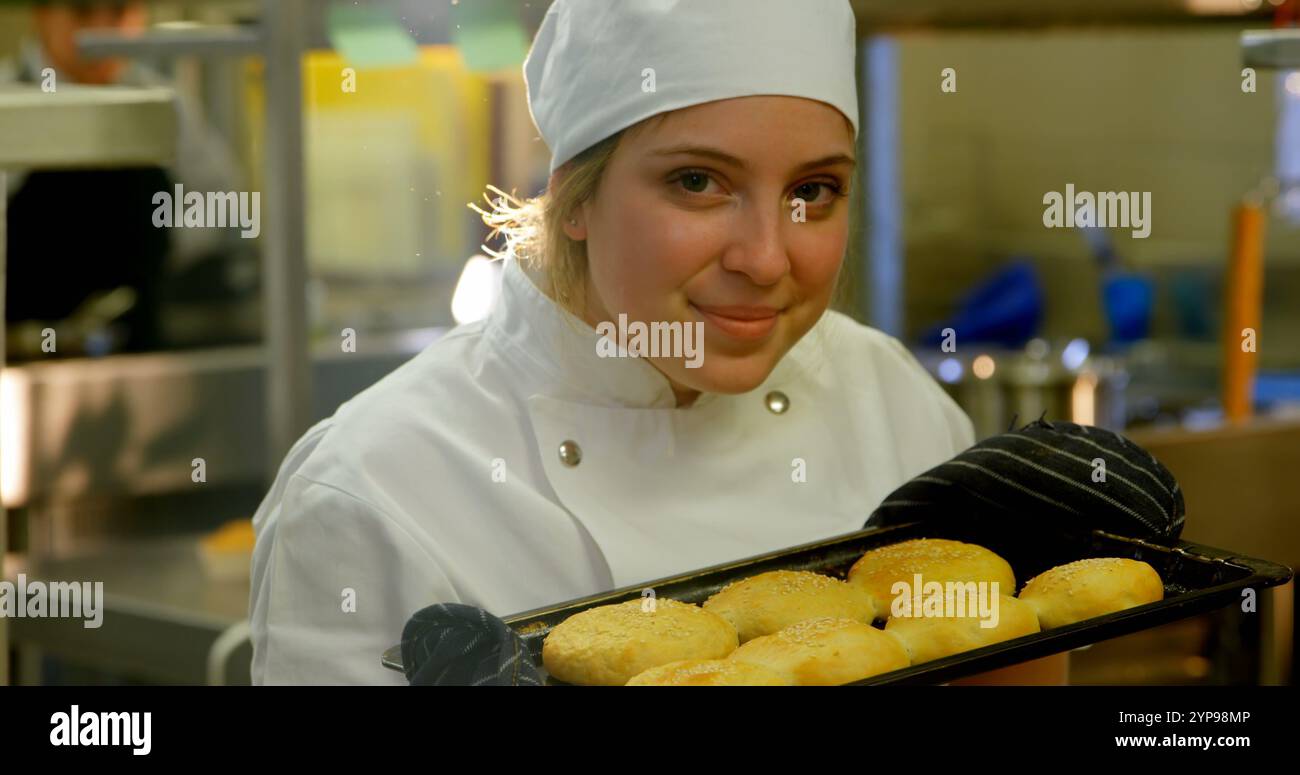 Ritratto di una chef che tiene un vassoio di biscotti in cucina 4k Foto Stock