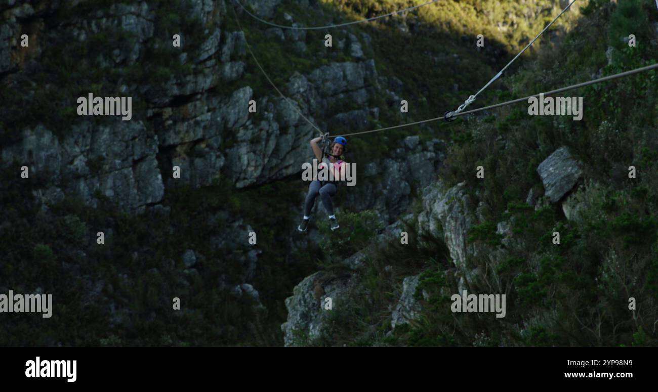 Vista frontale di una giovane donna caucasica con zip in una giornata di sole in montagna, al rallentatore Foto Stock