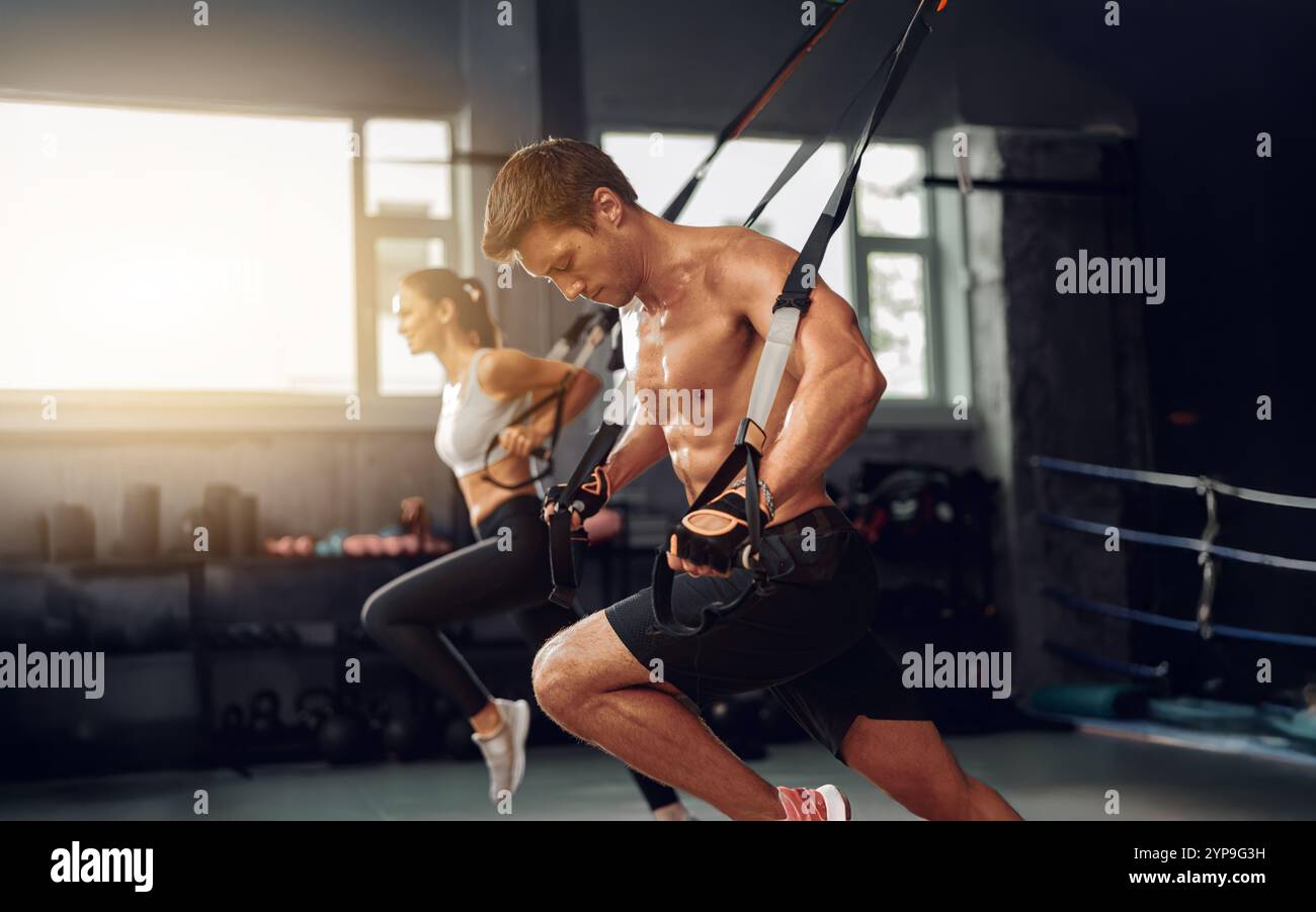 Allenamento dinamico ed efficace con allenamento delle sospensioni in un ambiente moderno di palestra Foto Stock