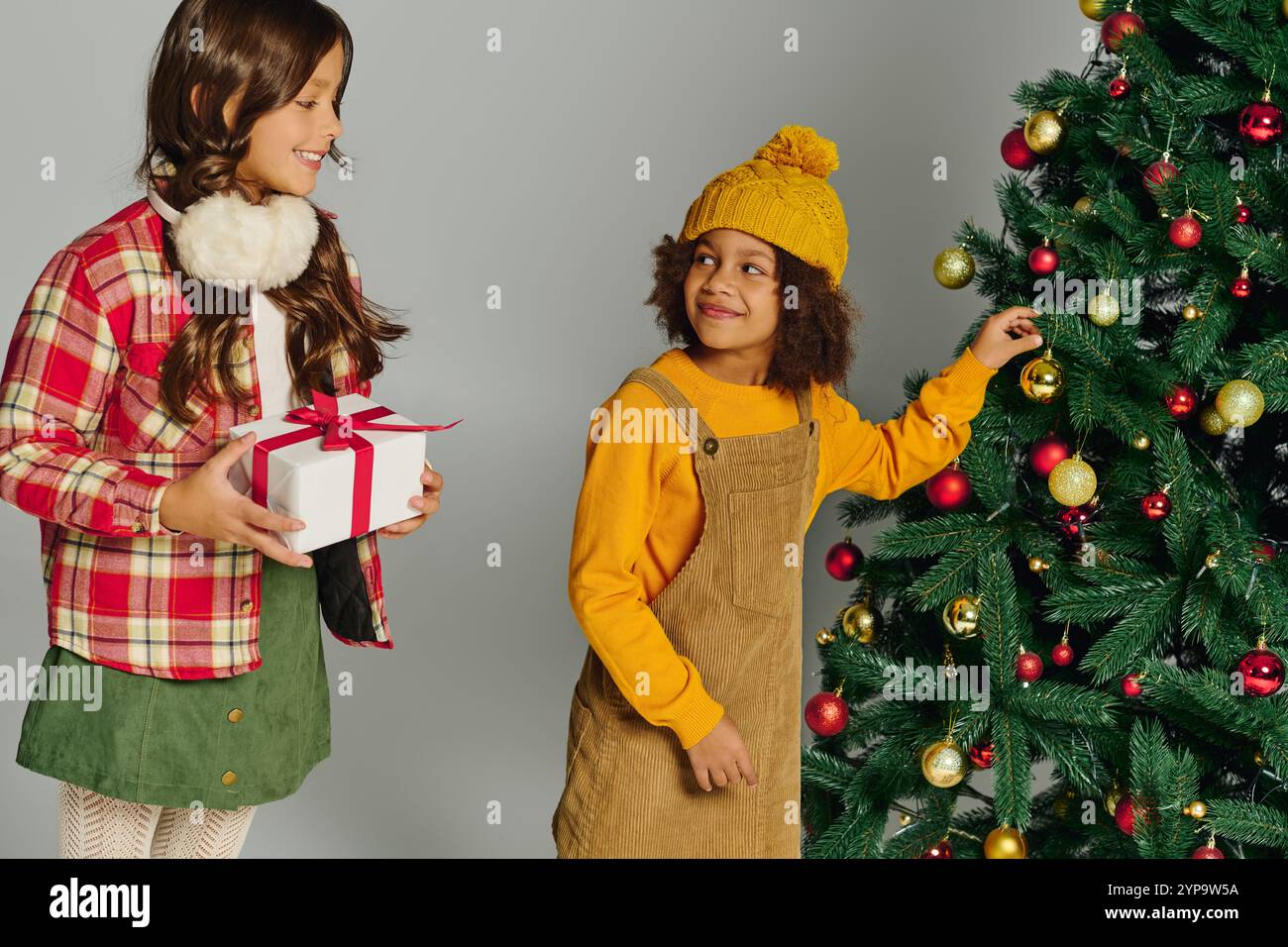 Due bambini pieni di emozioni, preparano un albero di Natale e condividono l'allegria festosa insieme. Foto Stock
