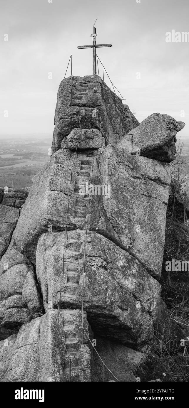 Una croce in legno si erge in cima alla formazione di granito Oresnik a Hejnice, le montagne di Jizera, offrendo splendide vedute del paesaggio circostante e un'esperienza unica di trekking. Foto Stock